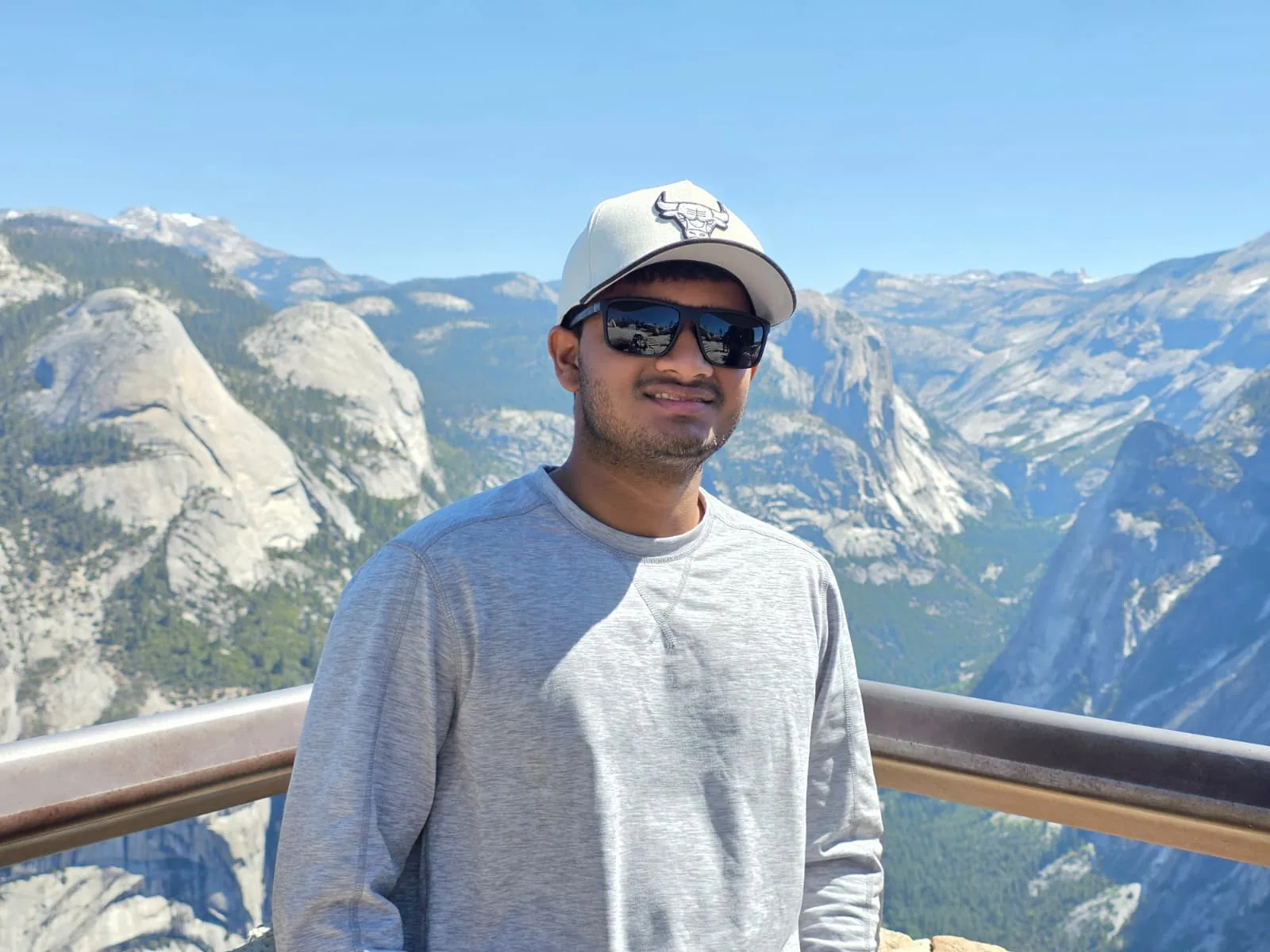 Saptarshi Joshi at a mountain overlook, with granite domes and a valley behind him
