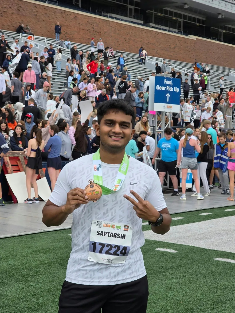 Saptarshi Joshi holding a finisher medal after the Illinois 10K